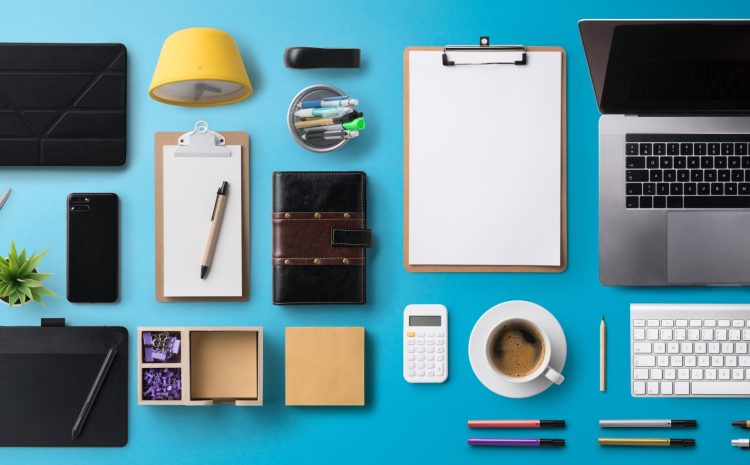 Flat lay top view office desk working space with laptop, tablet, smartphone and supplies on blue background.