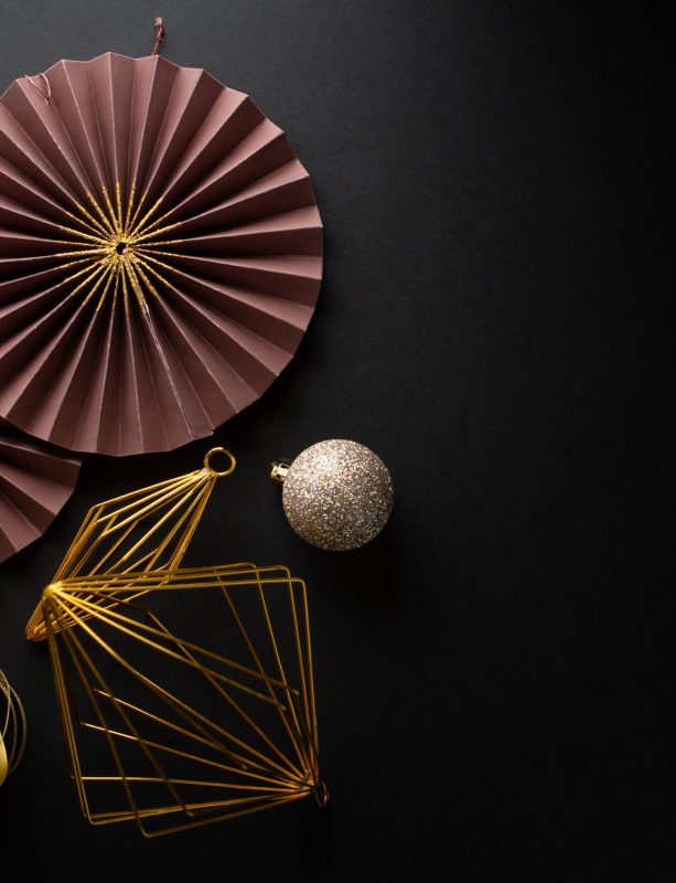 Christmas Flat Lay Background.  Gold Baubles and Christmas Deco on Dark Black Background. Minimalistic design. Copy Space. Horizontal.