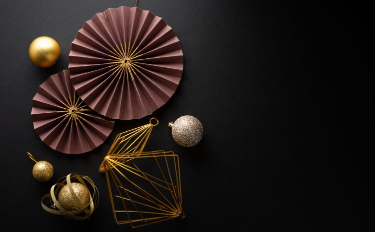 Christmas Flat Lay Background.  Gold Baubles and Christmas Deco on Dark Black Background. Minimalistic design. Copy Space. Horizontal.