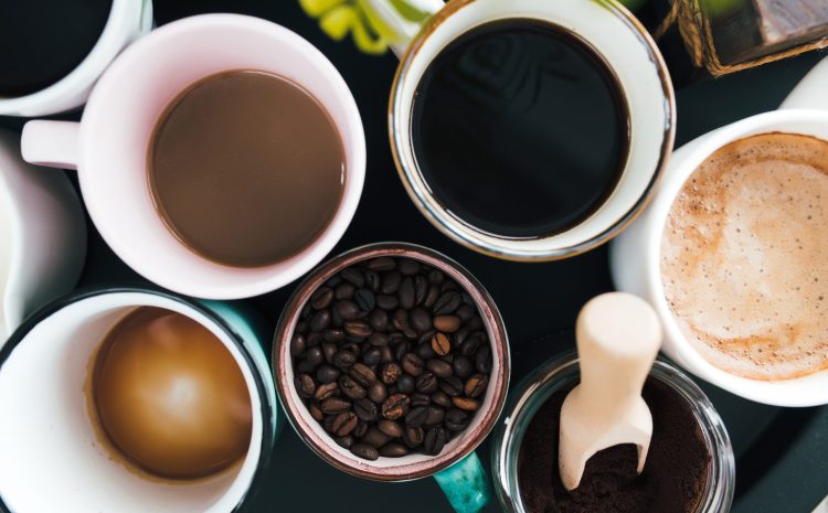 Multiple coffee cups, milk, beans and ground coffee in jar on black background. High quality photo
