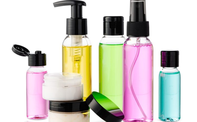 Variety of colorful personal care bottles and grooming accessories arranged on a clean white surface