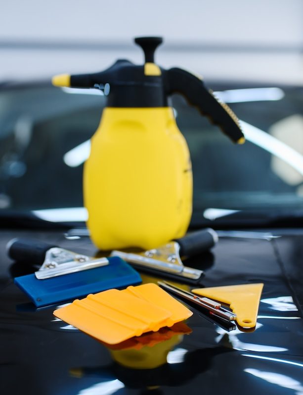 Tools for car tinting closeup, nobody, vehicle tuning service. Equipment for vinyl tint installation, business concept, tinted automobile glass